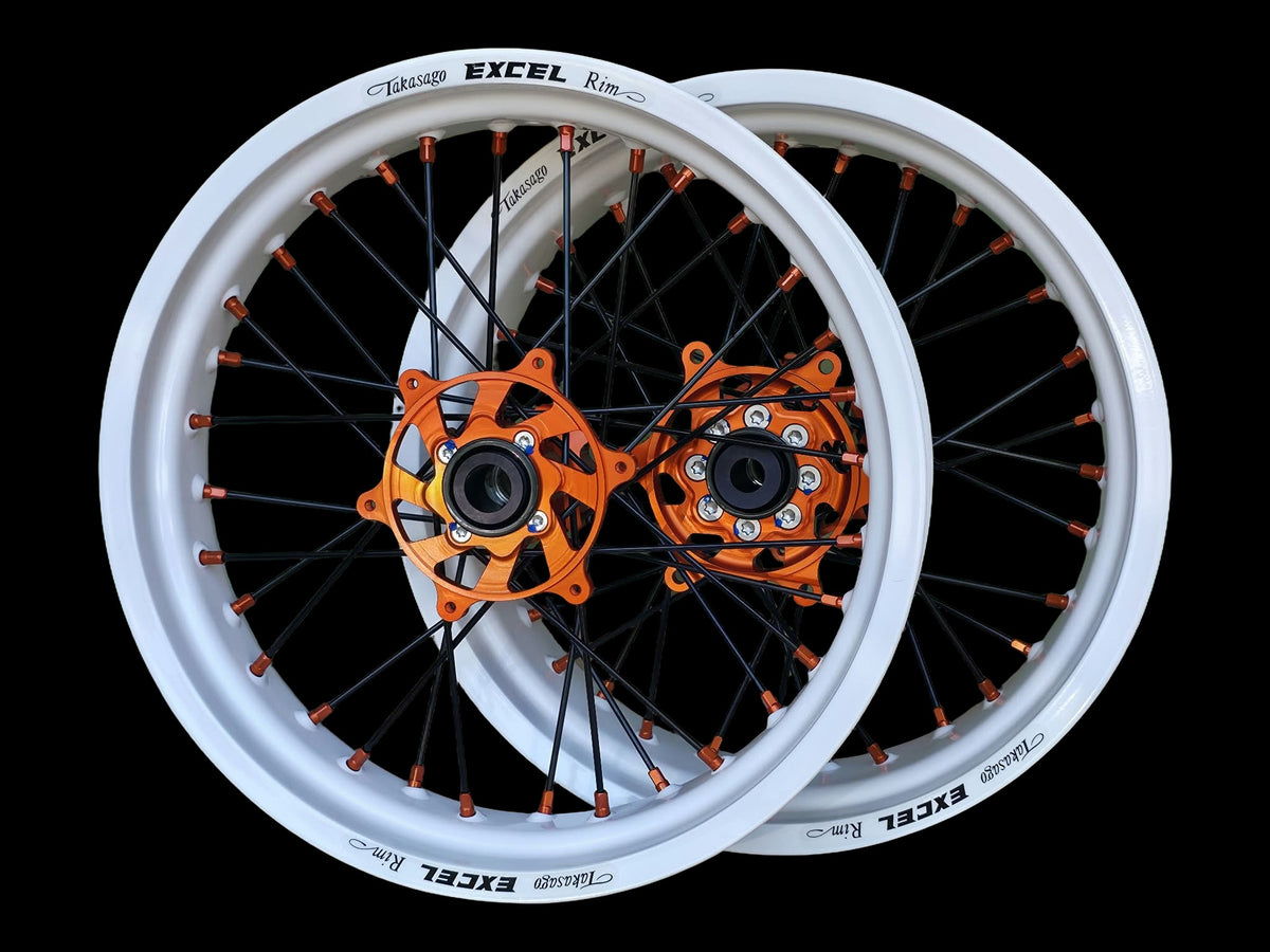 Supermoto Felgensatz 17 Zoll Excel RAL 9016 Verkehrsweiß mit G2 Pro Nabe Orange – vorne und hinten, schwarzer Hintergrund