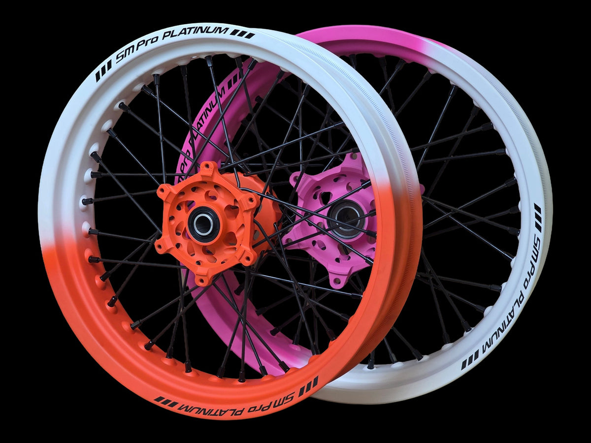 Supermoto Felgensatz 17 Zoll SM Pro Platinum Cerakote Hunter Orange / Prison Pink mit SM Pro Naben Hunter Orange und Prison Pink – vorne und hinten, schwarzer Hintergrund